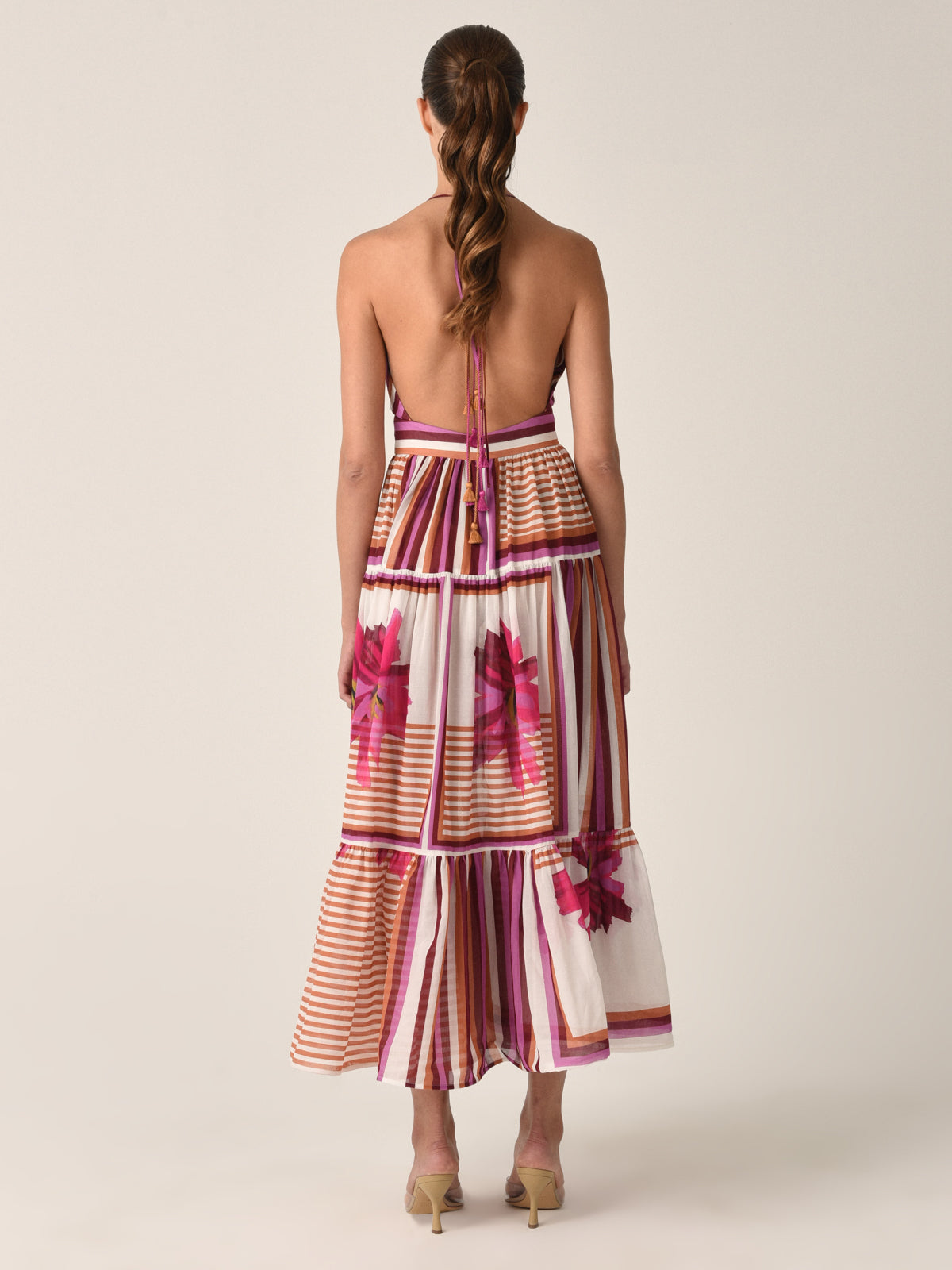 A Valerie Dress Magenta Floral Brushstroke Stripes with pink, peach, and white stripes and transparent sections with magenta floral brushstroke designs, isolated on a white background.